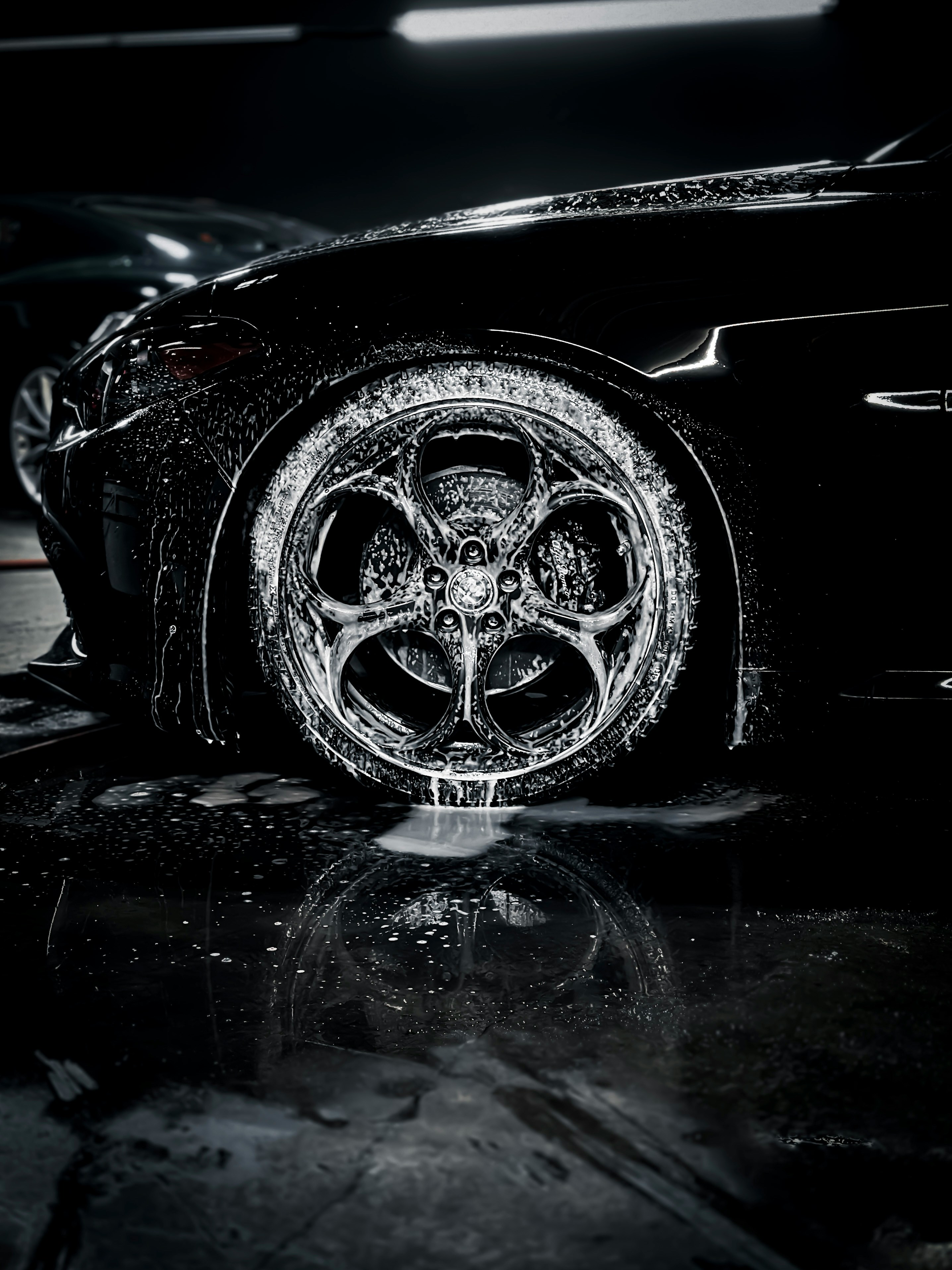 A soapy Alfa Romeo centered the the logo on the wheel, black and white.